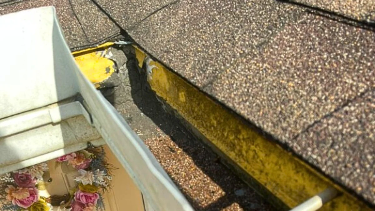 Gutter on a house with signs of trouble to represent the keyword what is granular loss on a roof.