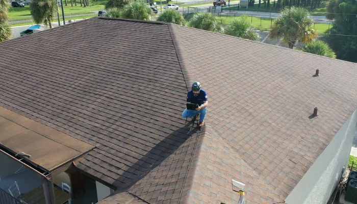 Man performing roof repairs to represent commercial roof replacement.