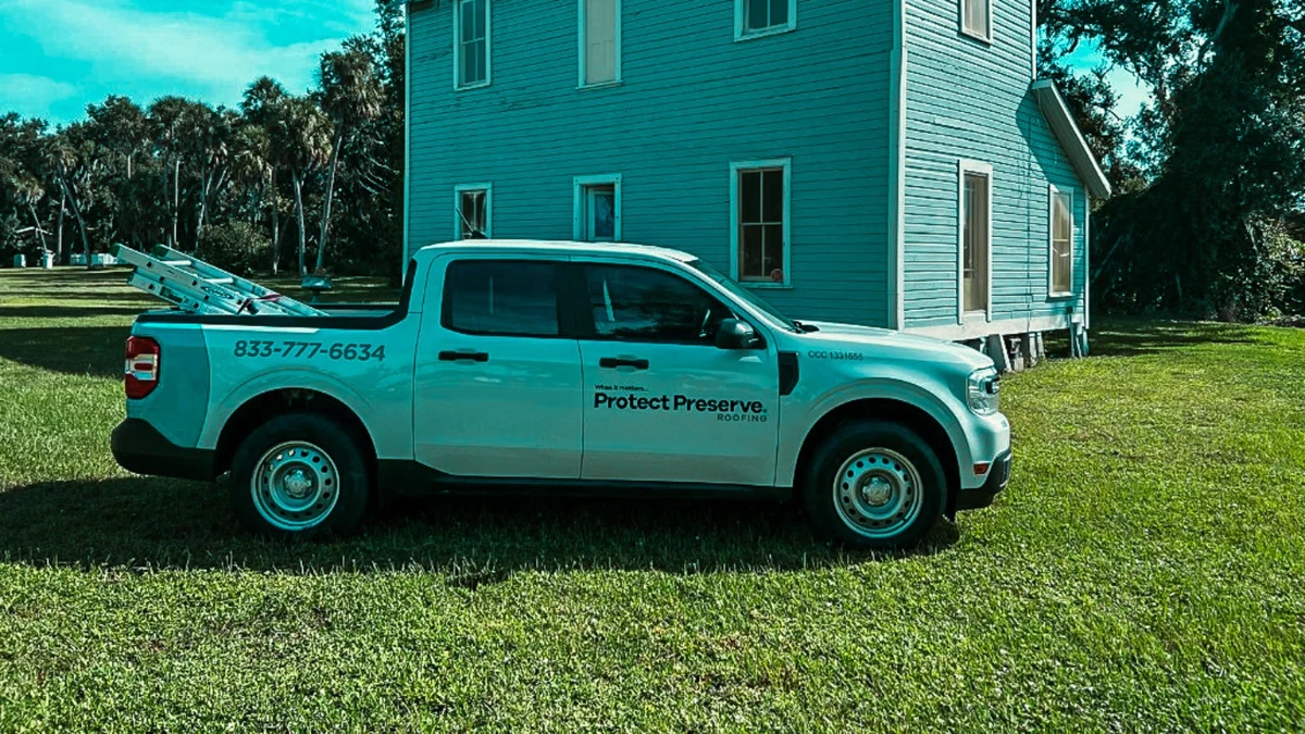 Pickup truck parked on lawn to represent keyword roofing companies near me.