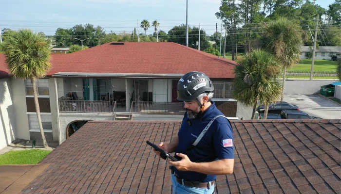 Man with equipment on top of a roof to represent the keyword roofing company in orlando.