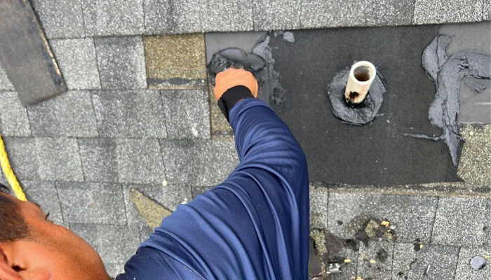 Man putting shingle on roof to represent keyword types of damage.