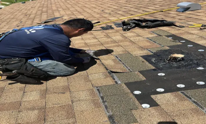 Roofer installing new shingles during a repair after what is a roof inspection revealed damage.