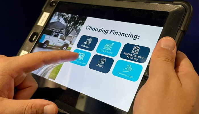 Black tablet with images indicating options to represent the keyword roofing finance options.