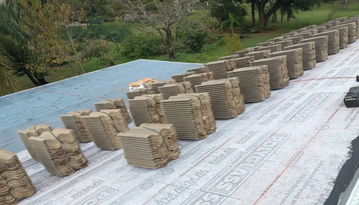 Stacks of concrete roofing tiles organized on a new underlayment during a roof replacement, highlighting material quality as a factor in how long do roofs last in Florida.