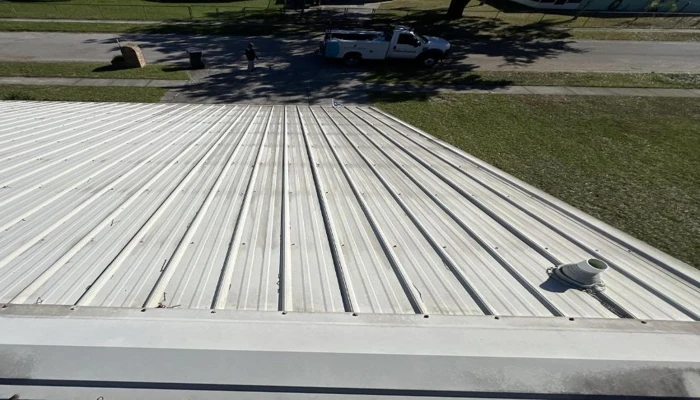 A wide view of a white standing seam metal roof installed on a Florida residence, highlighting its energy-efficient and heat-reflective properties in a comparison of metal roof vs shingles in Florida.